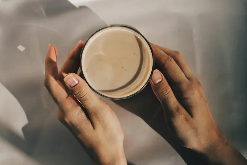 Person holding cup with coffee drink
