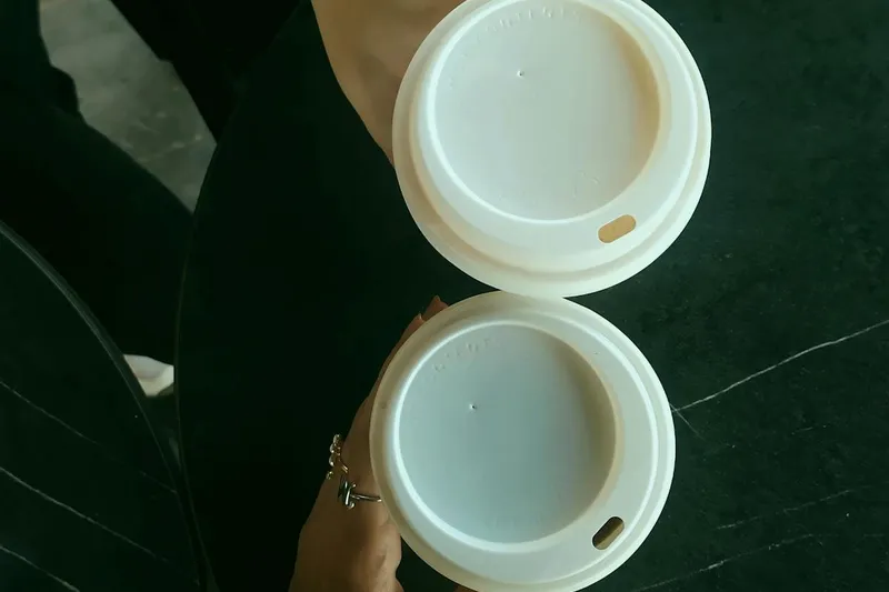 Close-up of two people holding coffee cups